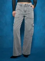 Jean cargo de tiro alto, color gris lavado, con corte ancho y pierna acampanada. Presenta bolsillos cargo grandes en los muslos y costuras marcadas.