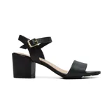 Sandalias negras de tacón ancho, con tira ancha sobre los dedos y pulsera al tobillo con hebilla dorada.
