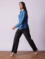 Camisa celeste de lyocell, marca Zac & Rachel. Cuello con solapa, abertura central con botones y bolsillos delanteros.