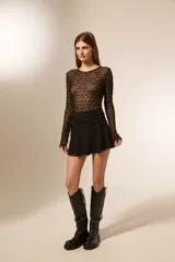 Minifalda blanca de poliéster con cintura alta y cordones laterales.