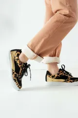 Championes negros con estampado animal print en tonos marrones y dorados.