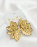 Aros colgantes dorados con forma de hojas.