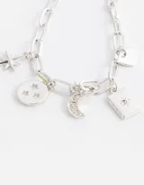 Pulsera plateada de eslabones con cadena de ajuste y dijes colgantes: estrella, moneda con diseño floral, luna creciente con strass, carta de tarot y corazón.
