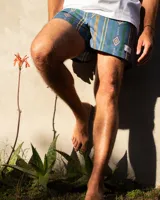 Short de baño azul con estampado geométrico en tonos marrón, verde y amarillo. Tiene cintura elástica con cordón ajustable.