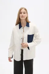 Chaqueta color crudo de algodón con cuello camisero y detalles en denim azul en cuello, bolsillo y puños.