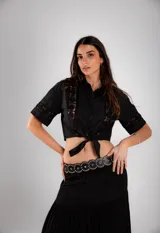 Camisa corta negra con detalles de encaje, de mangas cortas y anudada en la parte delantera.