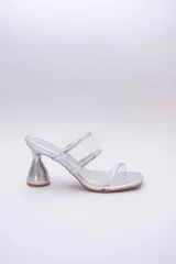 Sandalias plateadas con taco de forma geométrica y tiras transparentes.