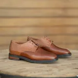 Zapato acordonado de cuero color marrón con detalle de textura reptil en el talón y empeine. Taco de madera foliado en cuero de 2,5 cm de altura y entre suela de goma de 1 cm.