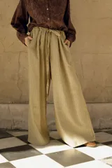 Pantalón de lana con estampado tartán en tonos beige y marrón, de corte amplio, cintura alta con elástico y lazo ajustable, y bolsillos laterales.