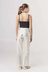 Pantalón de jean metalizado color dorado, de corte recto y tiro alto.