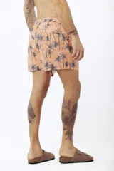 Short de baño con estampado de hojas de palmera en tonos beige, verde y naranja.