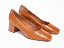 Zapato de cuero color marrón con textura de cocodrilo, de tacón cuadrado y puntera redondeada.