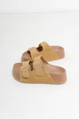 Sandalias color rosa con doble hebilla ajustable y suela marrón.