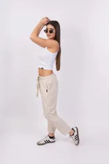 Pantalón capri a rayas verticales color verde y blanco, con cintura elástica y lazo ajustable.