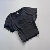 Remera corta gris con cuello redondo y mangas cortas con volados.
