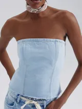 Top strapless de jean celeste con costuras verticales y terminación desflecada.