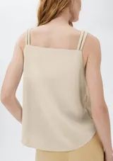 Musculosa color beige con escote en V y tirantes anchos ajustables con hebillas metálicas.