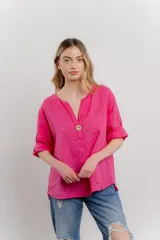 Blusa celeste de lino, con escote en V, manga tres cuartos y botón de madera.