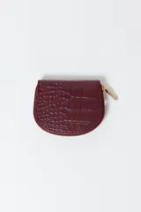 Monedero negro con textura troquelada y cierre dorado.