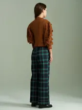 Cardigan marrón de tejido de punto con cierre frontal, cuello redondo y mangas abullonadas con apliques de pompones.