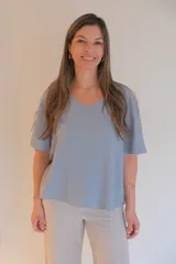 Blusa celeste de tela tipo jean, con escote en V y mangas cortas con volados.