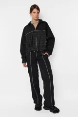 Campera negra oversize con combinación de textil deportivo y sastrero, cierre metálico YKK desmontable, elástico en puños y cintura, vivo a contratono en mangas y cuerpo, forrada al tono.
