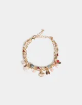 Pulsera flexible dorada de doble cadena con cuentas de colores y dijes de caracol y metal.