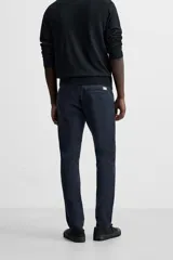 Pantalón chino azul marino, corte skinny fit, confeccionado en tejido de algodón con elasticidad. Cuenta con bolsillos frontales y traseros de vivo. Cierre frontal con cremallera y botón.