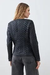 Chaqueta negra de cuero sintético con diseño acolchado en forma de espiga y detalles de tul.