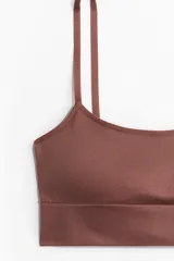 Bralette color ladrillo, de tejido suave y sin costuras, con breteles finos regulables y banda inferior acanalada. Tiene copas forradas con relleno extraíble.