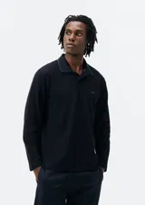 Polo de manga larga color negro con cuello clásico y borde verde.
