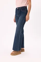 Jean wide leg de denim azul con tiro alto y cordones decorativos en la cintura.