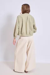 Cazadora color verde oliva con cuello redondo, cierre frontal con botones y mangas largas con puños elásticos.