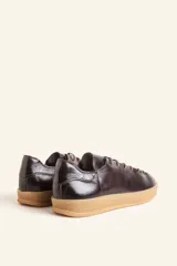 Zapatilla de cuero vacuno color azul marino, con cordones azules y suela de caucho color caramelo.