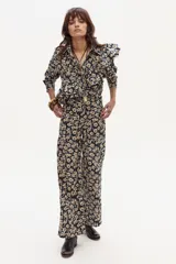 Pantalón de lino estampado con flores pequeñas en tonos crema y marrón sobre fondo azul marino. El pantalón es de tiro medio y tiene un corte ligeramente ancho en las piernas.