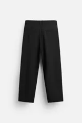 Pantalón negro de corte amplio, con pliegues en la parte delantera, bolsillos laterales y traseros de ojal.