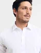 Camisa celeste de manga larga con cuello button-down, confeccionada en tejido rústico de algodón y lino.