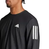 Remera deportiva de manga larga Adidas Own The Run, color negro con logo blanco en el pecho y tres tiras blancas en los hombros.