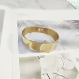 Brazalete abierto de acero quirúrgico color dorado.