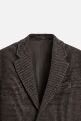 Blazer marrón con estampado pata de gallo, de corte regular fit, con cuello de solapas de muesca, manga larga con puños abotonados, bolsillo de vivo en el pecho, bolsillos de solapa en la cadera, bolsillo interior, aberturas en la espalda y cierre frontal con botones.