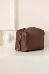 Necessaire de cuero vacuno color verde militar, con un diseño amplio y un bolsillo interno.