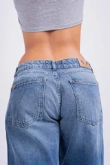Pantalón de jean celeste, corte wide leg, tiro bajo y bolsillos delanteros y traseros.