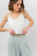 Pantalón negro de corte ancho y fluido, tiro medio con presillas para cinturón, bolsillos laterales funcionales y pinzas delanteras.