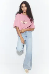 Remera rosa de corte amplio con estampado de girasoles y el texto "Van Gogh".