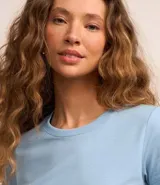 Remera básica de media malla color blanco, con cuello redondo y mangas cortas.