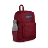 Mochila JanSport color borgoña con logo en etiqueta azul. Tiene un compartimento principal, bolsillo frontal con cremallera, bolsillo lateral para botella de agua, tirantes acolchados y panel trasero acolchado.