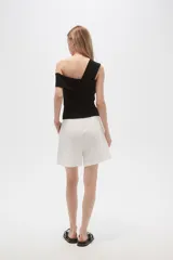 Bermuda blanca de viscosa con pinzas, corte holgado y tiro alto.