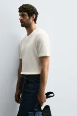 Camiseta de hombre de manga corta, color blanco con rayas horizontales azul marino. Confeccionada en tejido con estructura waffle y corte relaxed fit.