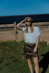 Camisa color ladrillo confeccionada en lino, con cuello mao, mangas cortas abullonadas y cierre frontal con botones.