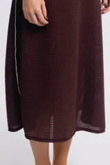 Vestido midi marrón de tejido waffle con breteles anchos y corte recto. Presenta aberturas laterales con ribete blanco y logo bordado en el pecho.